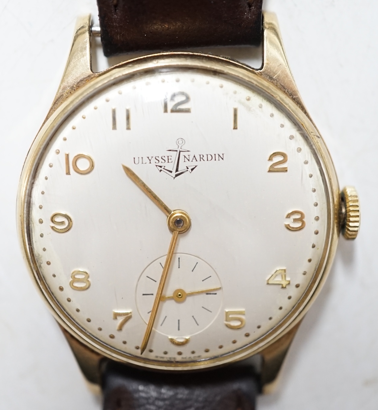 A gentleman's 9ct gold Ulysse Nardin manual wind wrist watch, with Arabic dial and subsidiary seconds, on associated leather strap. Condition - fair